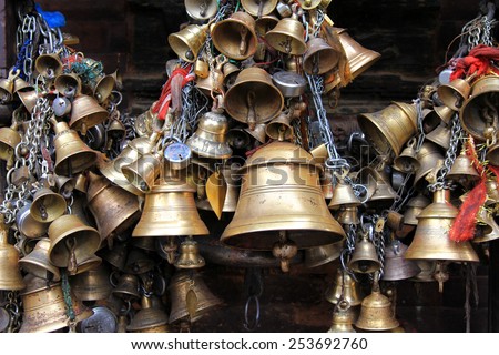 PATAN, NEPAL - APRIL 2014 : Metal sacrificial bells hanging on chain at Kumbeshwar Temple on 13 April 2014 in Patan, Nepal. Bell is one of the worship materials to Hindu Goddess.