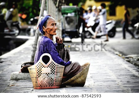 Old asian woman watches what is happening on the street