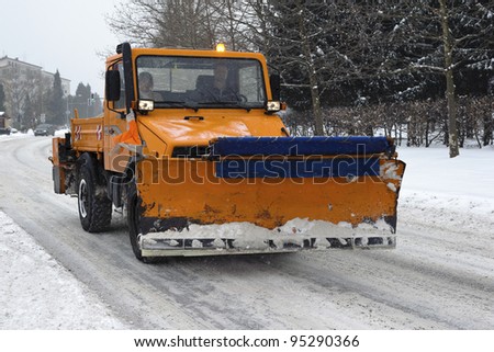 A orange snow plow truck ready for the storm