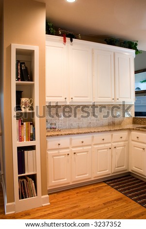 Modern kitchen with granite counter, tile backsplash and bookcase