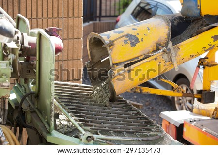 Housing construction. Ready-mixed concrete injection from the concrete mixer truck to pump car.