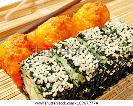 rolls with black roe and sesame and baking sushi on bamboo mat