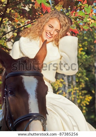 smiling bride siting on her horse in forest