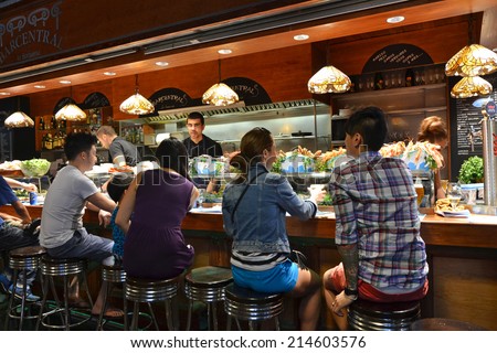 Barcelona - August 21: customers seated at a tapas bar at La Boqueria market in Barcelona, Spain on Augut 21, 2014. The market is one of the oldest in Europe and a popular tourist attraction.