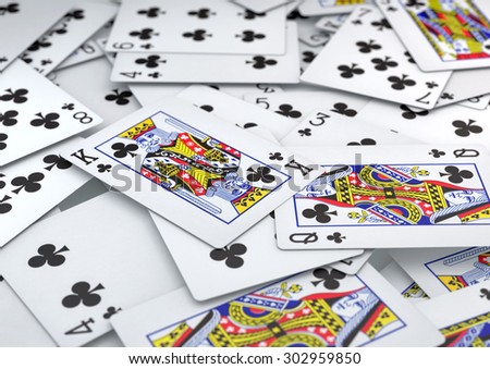 Pile of cards heart suite spread out and lying on table with depth of field. King and Queen of clubs are focal points. Background texture or image.