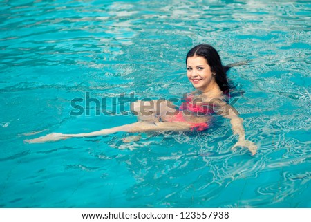 Beautiful woman floating in a swimming pool.