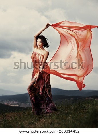 The girl in a beautiful dress in the wind