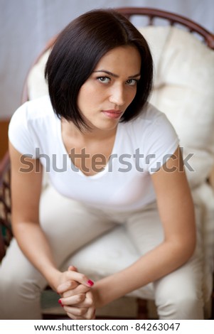 Portrait of beautiful brunette young woman sitting in the chair