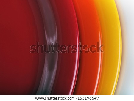 orange, yellow and red colored  plates stacked upon each other. This set of kitchen ware is made of melamine plastic