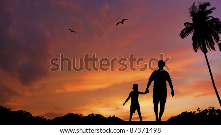 silhouette of father and sun walking together