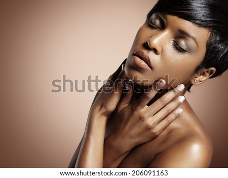 black woman with closed eyes touching her face