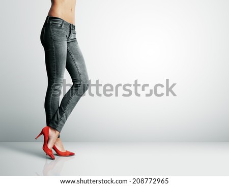 woman in black jeans standing in grey room