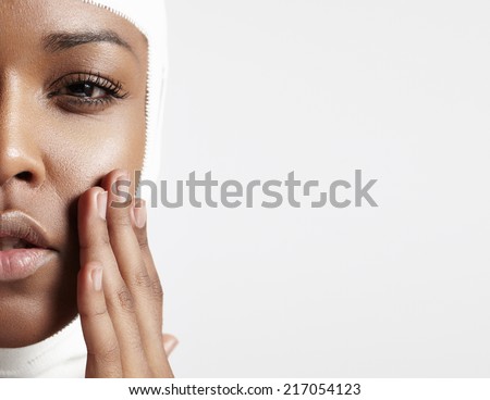 half a face of a black woman with a bandaged head