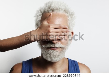woman's hand close over the eyes of a man