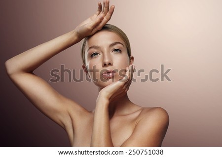 woman on a dark colored background with touching her ideal skin