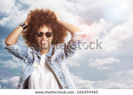 happy woman with a afro hair on a sky background