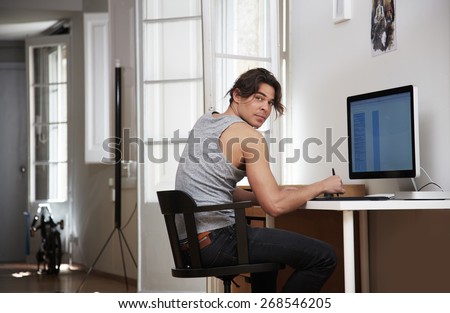 man working in his apartment, looking back