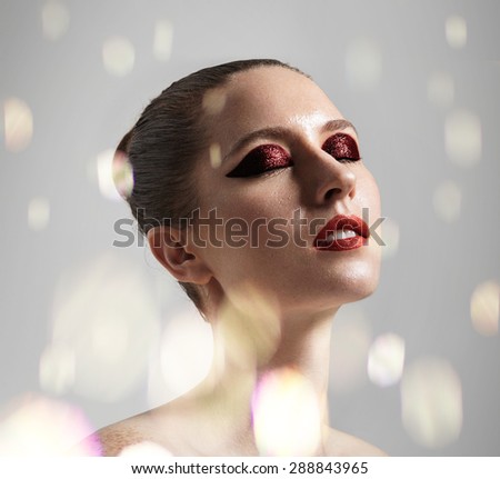 beauty woman with a bright shine eye shadows, red lips and bokeh