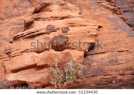 Funny face on a red rock cliff wall