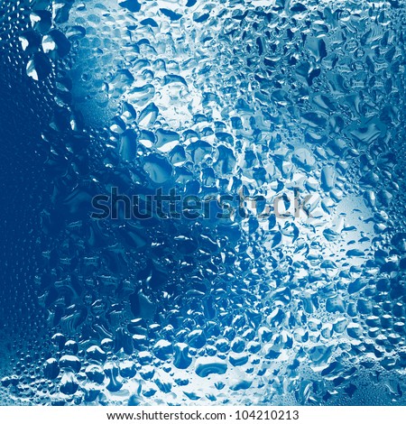 The background of blue water. Streams of water. Drops of water