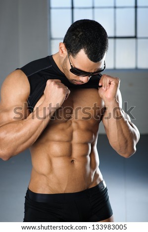 Male bodybuilder fitness model looking at six pack abs