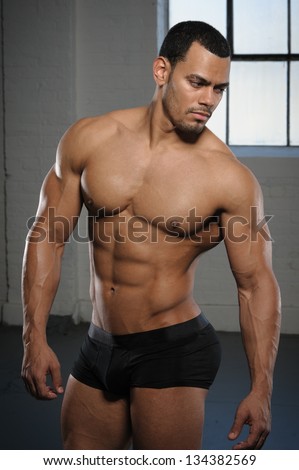 Male Fitness Model with six pack abs.   Bodybuilder fitness model posing in photo studio