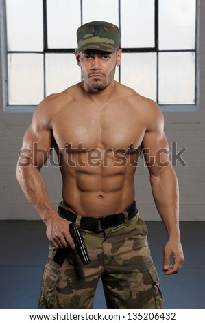 Muscular Army man in camouflage, no shirt with six pack abs