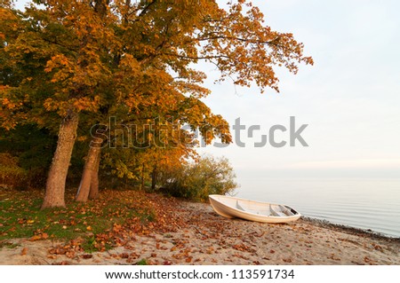 Lakeside with a boat in autumn sunrise