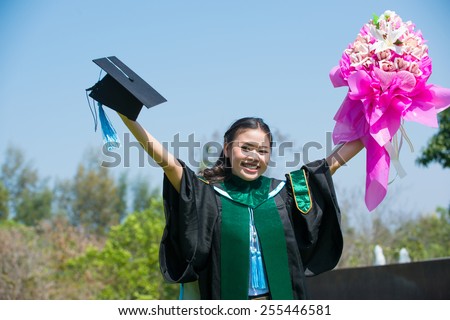 pretty young woman celebrating joyfully her graduation spreading wide her arms above her head