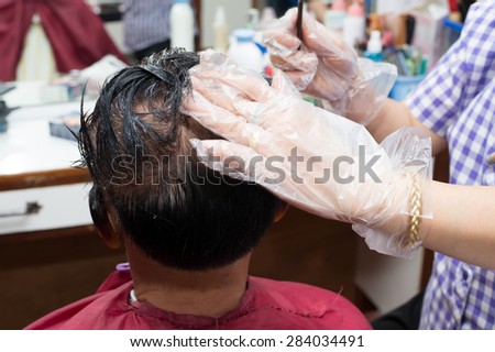 a middle aged Asian man making hair dye at a beauty salon
