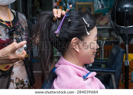 a beautiful woman making hair bun at a beauty salon