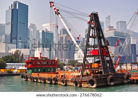 HONG KONG-SEPTEMBER, 2012: Barge building the new pier in the port of Hong Kong. View from the port of the island of Hong Kong\'s skyscrapers.