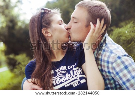 Happy couple in love kissing in the park
