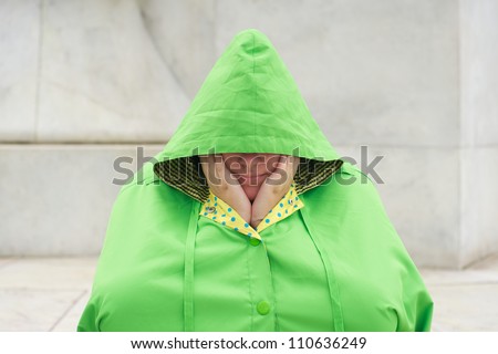 Teen wearing a rain poncho waiting for the rain