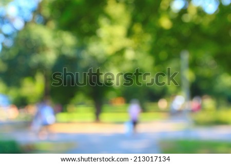 Defocused background of summer park with walking people