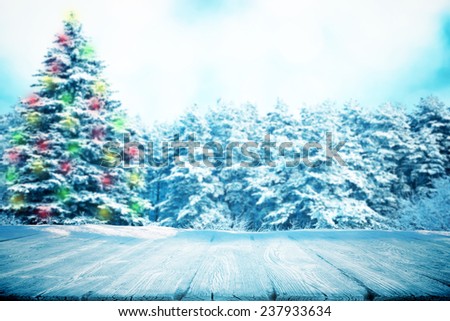 Wooden path in snow in forest with color fir tree in garland
