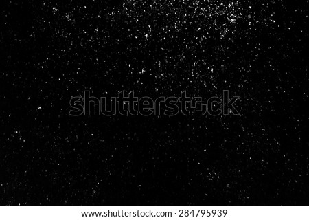 Powder particles or snow flying over the black background