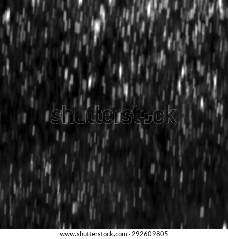 Snow or rain or powder particles flying over the black background, for use as overlay layer. Blurred effect.