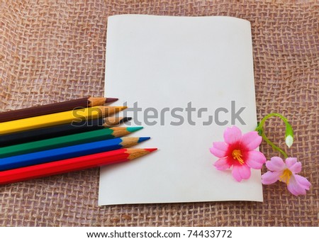 Photo card on sack material with colorful pencils and flowers
