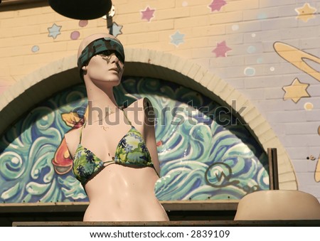 fun fashion, beat up mannequin with trendy bathing suit