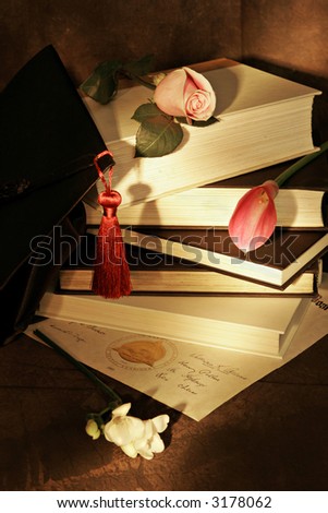 painting with light. Graduation cap with books,diploma and flowers, warm tones