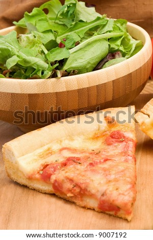 a fresh garden salad with a slice of pizza