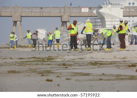 PENSACOLA BEACH - JULY 7: oil workers continue to clean the beach of oil on July 7, 2010 in Pensacola Beach, FL.