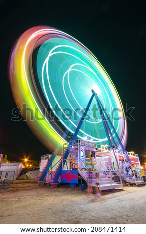 COLLADO VILLALBA, SPAIN - JULY 28: Long exposure picture of a Ferrys wheel rotating in a small local amusement park on July 28, 2014 in Collado Villaba, Madrid, Spain.