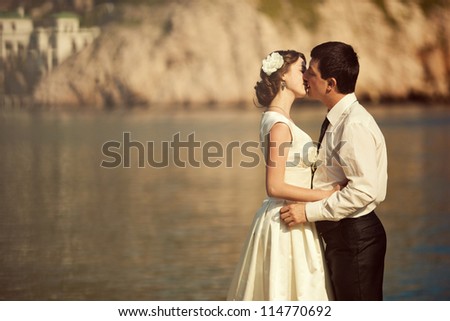 Young beautiful couple kissing at the sea. Wedding kiss.