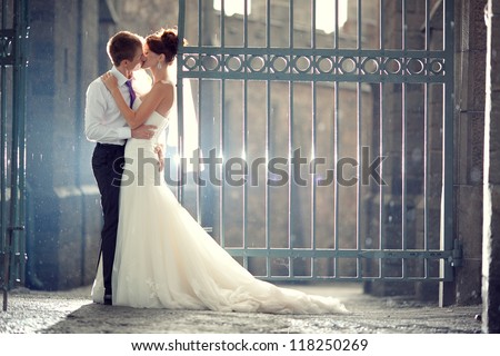 wedding pair hugging and kissing at the gate