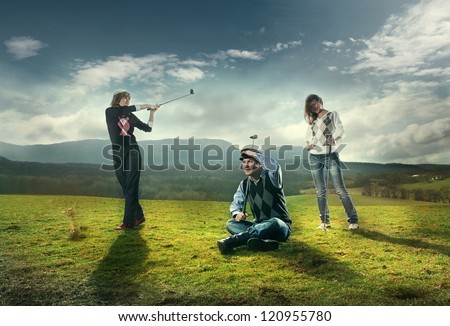 Three players play on the golf course in golf. wonderful sky formation in background.
