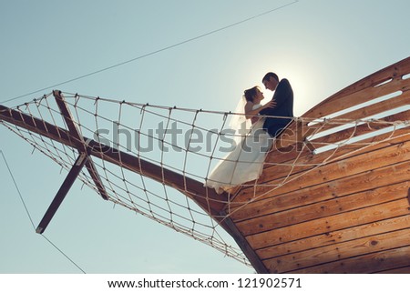 young couple bride and groom kiss on the bow of the ship restaurant. wedding theme.