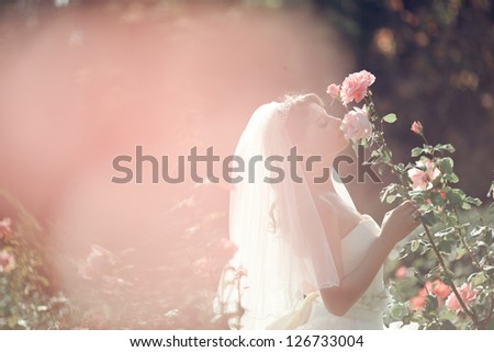 Beautiful Bride smell the roses. Wedding theme with flowers
