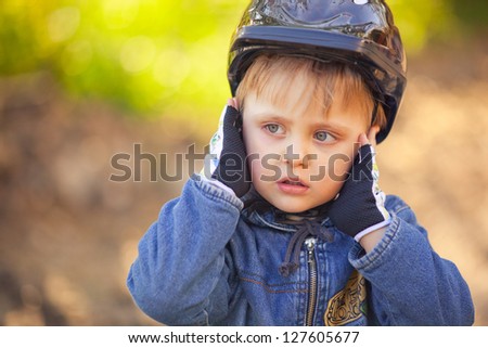 portrait of a little boy covers his ears cyclist